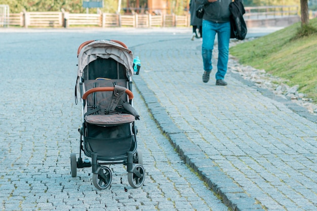 Lege kinderwagen staat op de straat van de stad Verloren kind Kinderen Sociaal probleem Gevaarlijk Gevaar Stoep Leven Ouders Vervoer Slechte wet Vermist kind Probleem Veiligheid