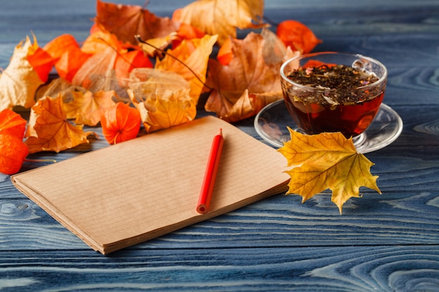 Lege Kladblok en kleurrijke herfst esdoorn bladeren op houten tafel achtergrond