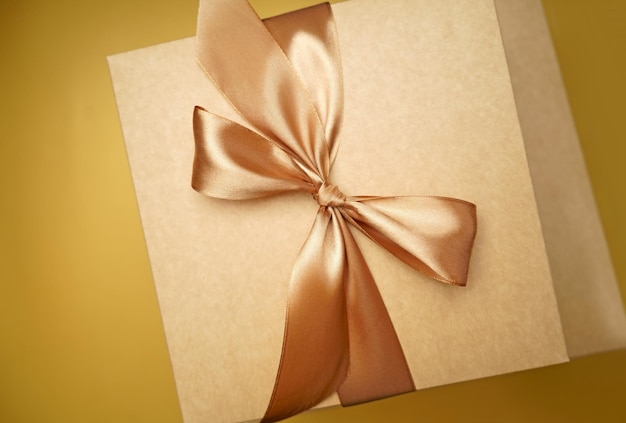 Lege label sticker voor tekst Gelukkig Nieuwjaar pakket bovenaanzicht Vierkant geschenkdoos ambachtelijke papier gele kleur boog knoop linten papier gele achtergrond