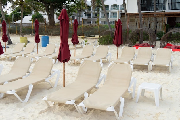 Lege ligbedden op het zandstrand Opgevouwen parasols hotelstrand zonder toeristen