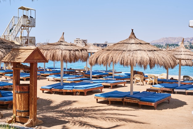 Lege ligstoelen met paraplu op strand