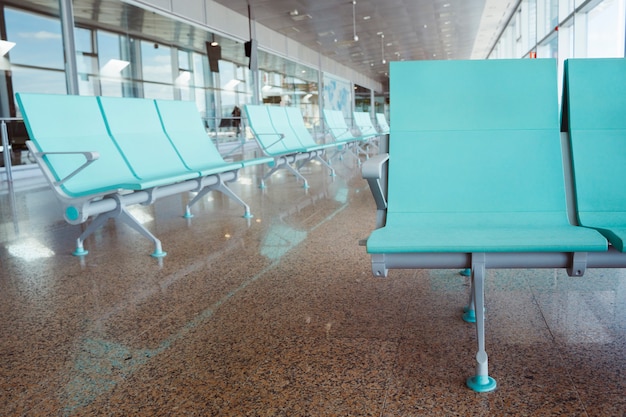 Lege luchthavenstoel met niemand die op de vraag van het vertragingsvliegtuig met niemand wacht. Vluchtannuleringen en reisconcept. Toerisme en vakantielevensstijl in Europa.