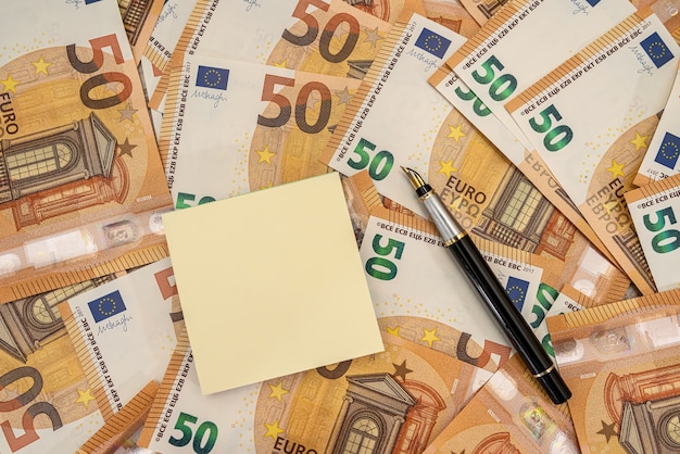 Lege memo's met pen en 50 Euro-bankbiljetten. Financieel en telconcept
