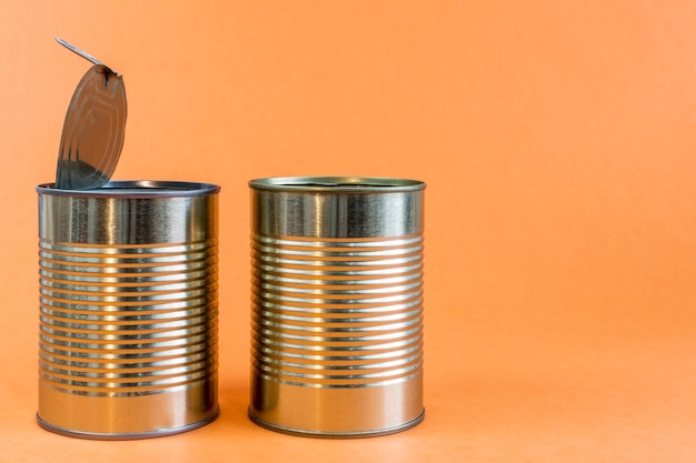 Lege metalen blikken en blikken op een oranje achtergrond Recycling concept en milieu