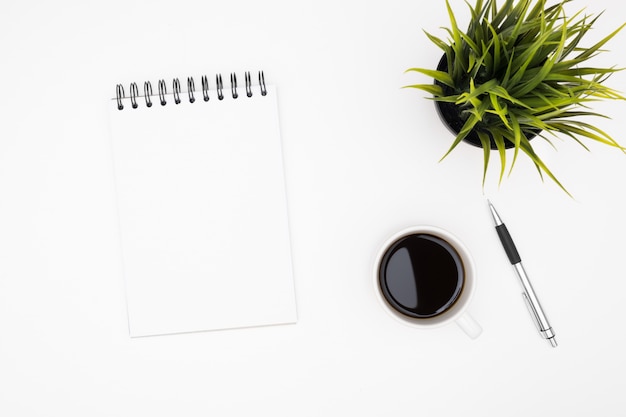 Foto lege notebook met pen zijn op de top van witte office tafel met een kopje koffie.