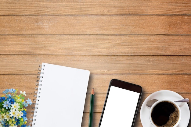 Lege notebook slimme telefoon en koffiekopje op houten
