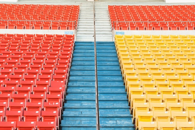 Lege oranje en gele stoelen in stadion Rijen stoelen op een voetbalstadion