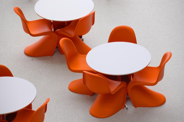 Foto lege oranje stoelen rond ronde witte tafels vergaderen