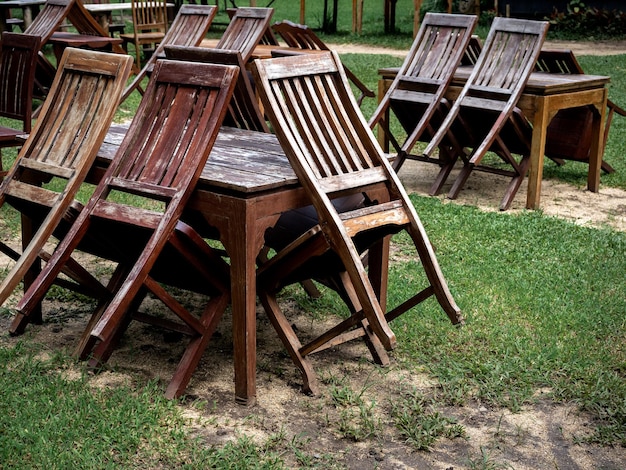 Lege oude verlaten houten eettafel in de groene tuin Buitenrestaurant permanent gesloten met oude eettafel geen gebruik