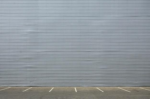 Lege parkeerplaatsen op de achtergrond van een metalen muur met ruimte voor productplaatsing