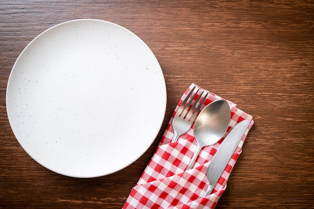 lege plaat of schotel met mes, vork en lepel op houten tafel