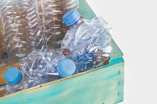 Lege plastic flessen in een blauwe houten kist