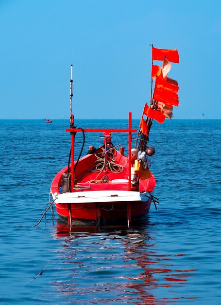 lege rode boot op zee tegen een heldere blauwe hemel