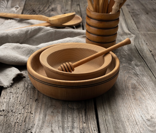 Lege ronde houten platen en lepels op grijze tafel, honingstok