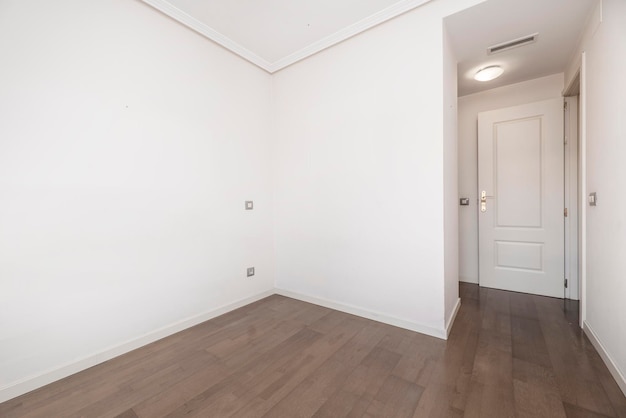 Lege ruimte met donker gelakte houten vloeren en bruin aluminium raam en witte aluminium radiator