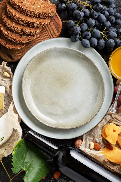 Lege serveerschaal in het middenframe gemaakt van honing druiven kaas snack andere voedselingrediënten gastronomie voorgerecht snacks. bespotten kopie ruimte of sjabloon op blauwe plaat schotel top verticaal.