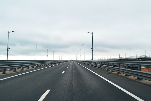 Lege snelweg met asfaltweg en bewolkte hemel