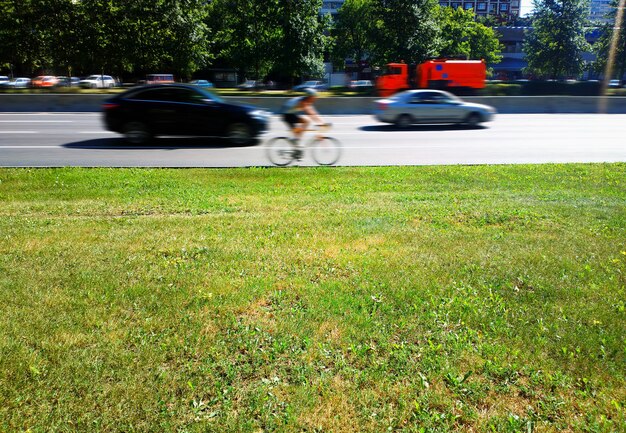 Lege stadsweg met gemengd verkeer en groene grasachtergrond