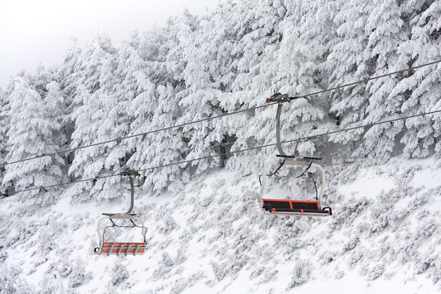 Lege stoeltjeslift in berglandschap bedekt met sneeuw. Ruimte voor tekst.