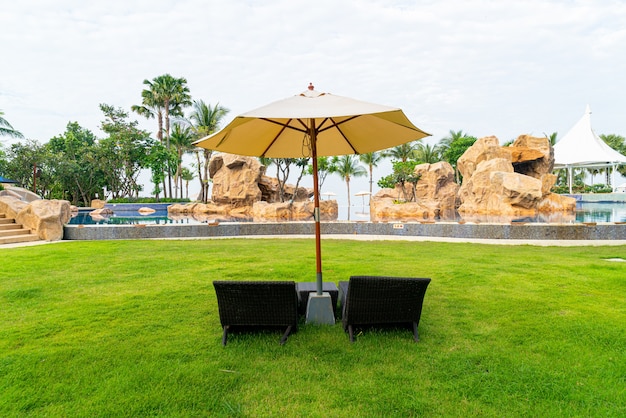 lege strandstoel met parasol rond zwembad