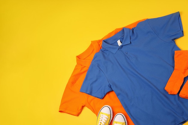 Lege t-shirts, sneakers en sokken op gele achtergrond