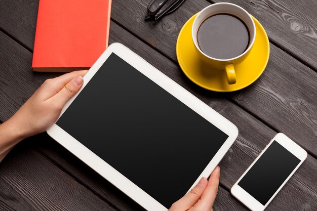 lege tablet apparaat over een houten werkruimte tafel met koffie bovenaanzicht