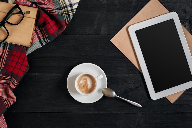 Lege tablet een kopje koffie notebook op het bureau tablet kopje warme koffie op oude vintage houten bord...