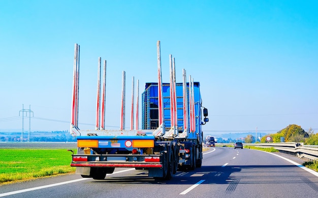 Lege vrachtwagen in de zomerweg van Polen. Vrachtwagenchauffeur op de snelweg. Vrachtwagen die logistiek werk doet. Oplegger met chauffeur. Grote vrachtauto rijden. Vracht levering. Transport export industrie. Container met goederen