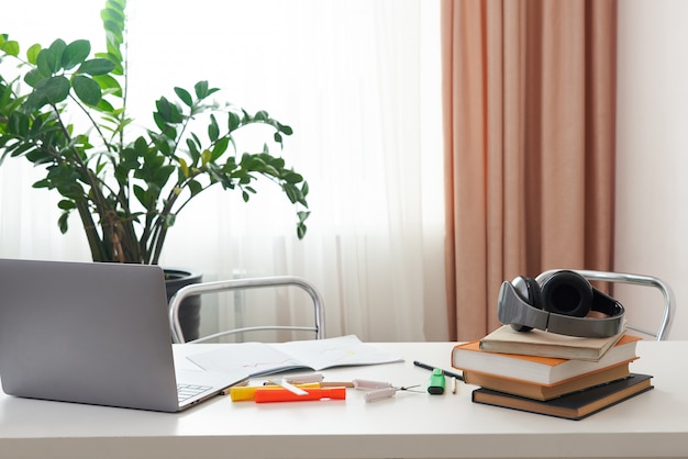 Lege werkplek met laptop en boeken op een bureau, interieur van student of freelance werknemer, comfortabele binnenlandse werkplek thuis