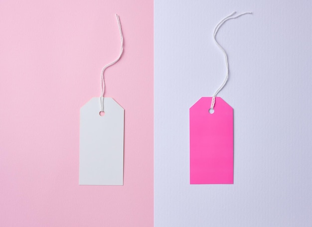 Lege witte en roze kartonnen tag op een witte touw roze achtergrond Prijskaartje sjabloon