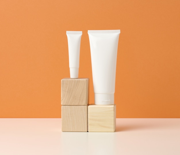 Lege witte plastic buizen voor cosmetica op een witte tafel. Verpakking voor crème, gel, serum, reclame en productpromotie, mock-up