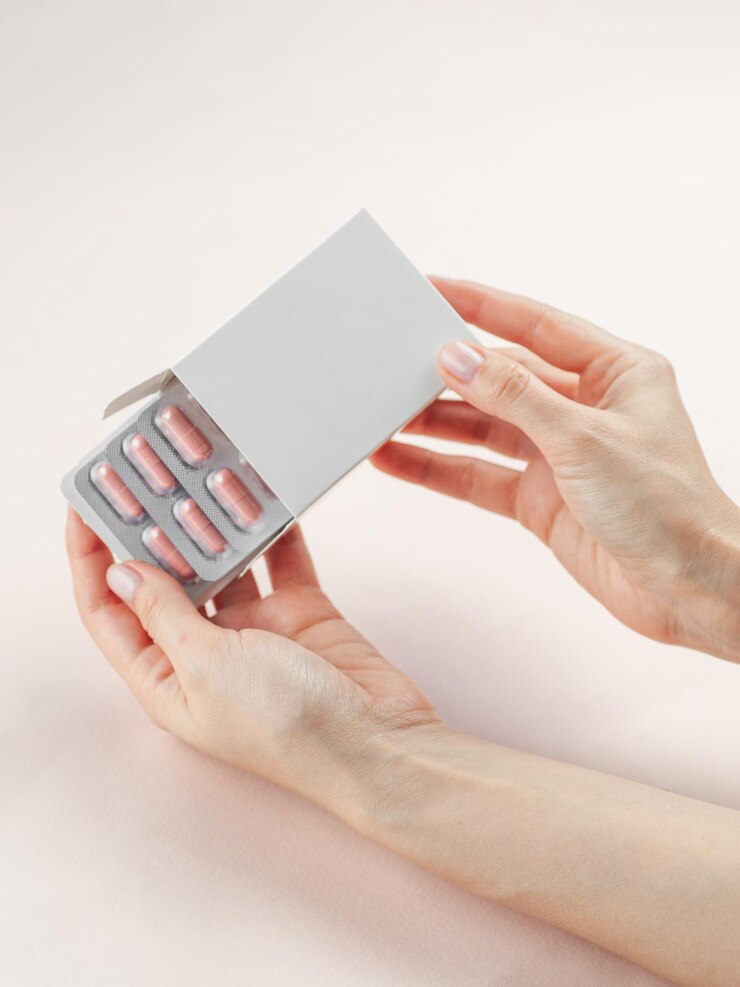Lege witte productpakketdoos Mockup in een vrouwelijke hand Open lege medicijndoos met vitamine een blister bovenaanzicht Plaats voor logo en tekst