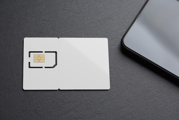 Lege witte SIM-kaart met smartphone op zwarte leisteen 3D-rendering en foto