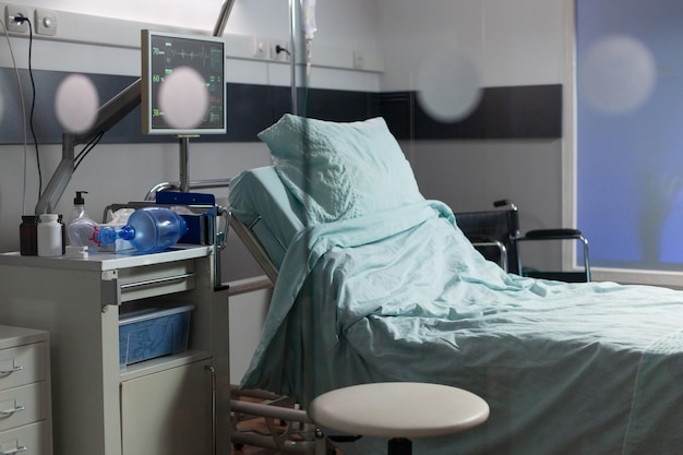 Lege ziekenhuiskamer met niemand erin met een eenpersoonsbed, comfortabel bed, moderne apparatuur. Herstelkamer van ziekenhuisafdeling, steriele vloer. Ambulante kamer na de operatie.