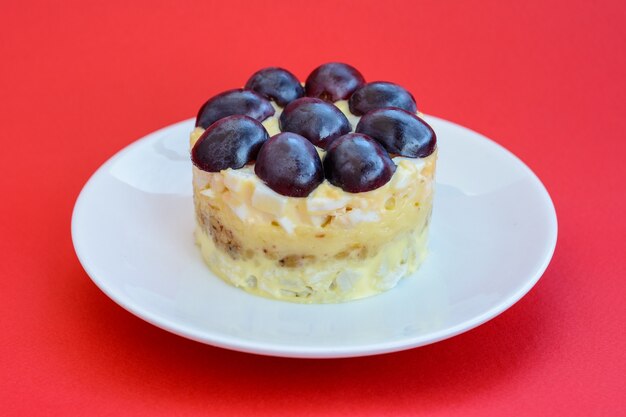 The legendary Tiffany layered salad with grapes, chicken and cheese on the red background. It got its name from the nickname of the lady who posted the recipe of the salad on the culinary portal.