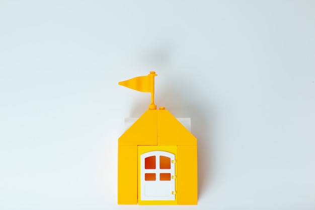 Lego house, stay home stay safe. Yellow toy house with lego family. Self-isolation during virus. Home office with family.