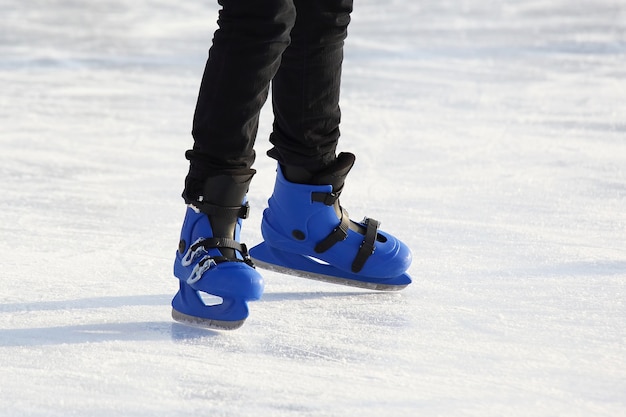 Legs in blue skating on the ice rink