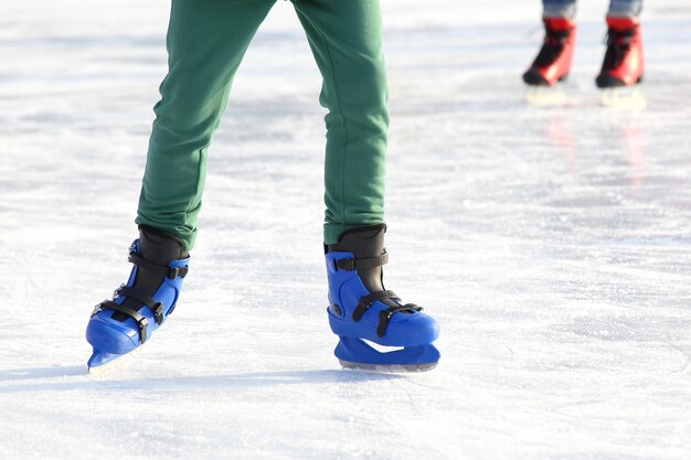 Legs in blue skating on the ice rink