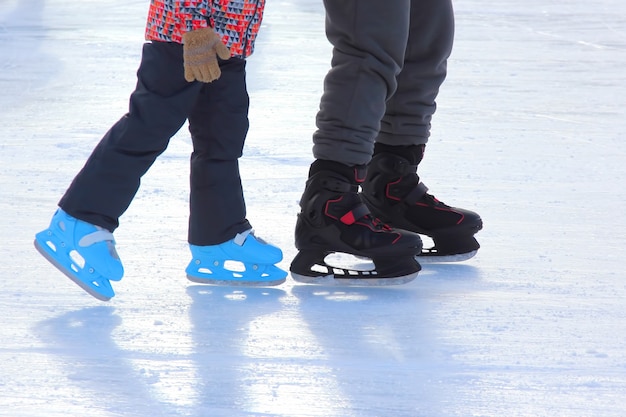 The legs of the child and adult ice skating rink