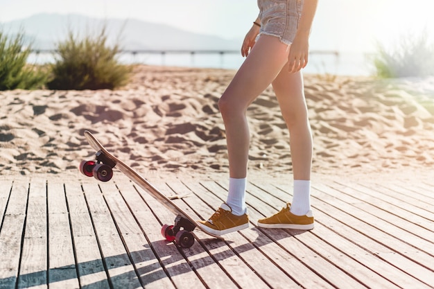 Legs of a female skater pushing the skate down wearing shorts