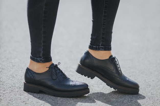 Legs of a female wearing fashionable black loafers