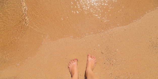 Gambe di una ragazza in riva al mare