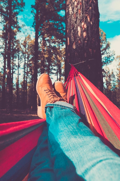 Legs and hammock relax leisure activity with forest woods and sky in background people enjoy environment and alternative free lifestyle enjoying nature and alternative vacation or weekend alone