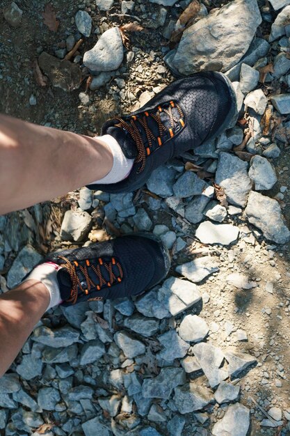 Legs of hikers on mountain rocky surface