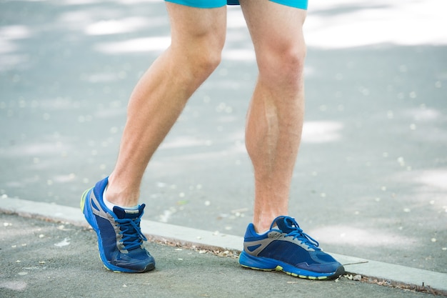 公園の歩道をジョギングしている男性アスリートランナーの足。アクティブなライフスタイルトレーニングカーディオスポーツシューズ。血管疾患の静脈瘤は活動的な生活を問題にします。静脈瘤の概念を防ぎます。実行によって引き起こされる病気。