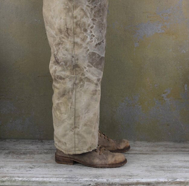 Photo legs of a man in old pants and old shoes