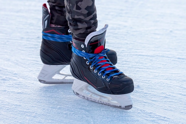 Legs of a man skating on an ice rink. Hobbies and sports. Vacations and winter activities