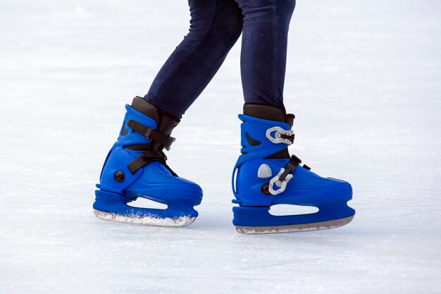 Legs of a man skating on an ice rink. Hobbies and sports. Vacations and winter activities