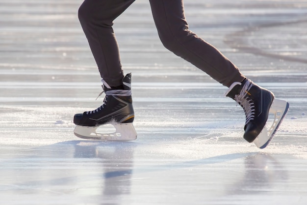 Legs of a man skating on an ice rink. Hobbies and sports