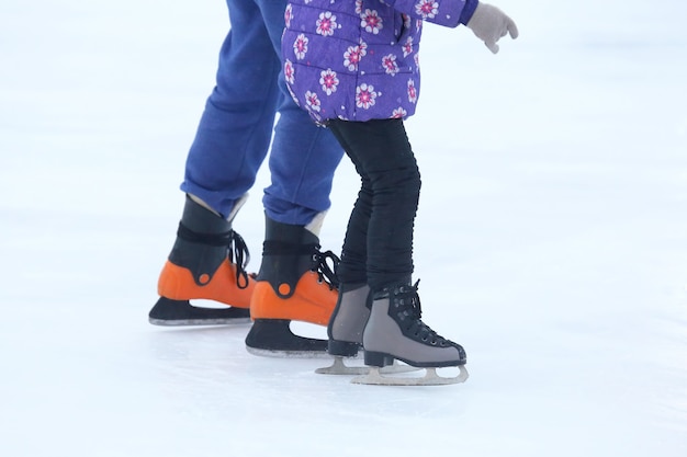 The legs of a man skating on an ice rink